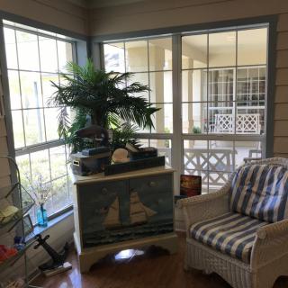 A cozy sunroom with nautical decor and abundant natural light.
