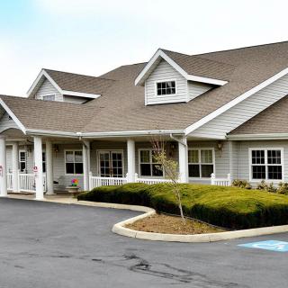 A well-maintained residential building with a sloped roof and a surrounding driveway.