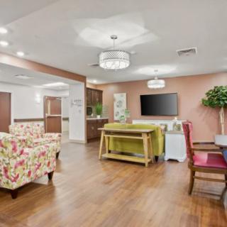 A cozy living room with floral-patterned furniture, wooden flooring, and modern decor.
