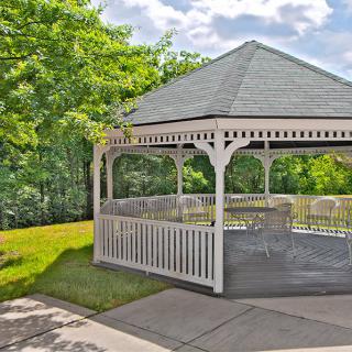 A charming white gazebo in a lush garden setting.