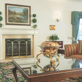 A cozy living room with a fireplace, elegant decor, and a glass-topped coffee table.