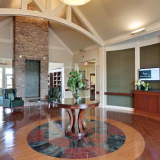 A spacious and elegantly designed lobby area featuring a central table, contemporary furniture, and a welcoming atmosphere.