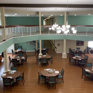 Spacious dining area with multiple tables and a balcony overlooking the room.