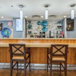 A modern bar area with two chairs at the counter and sleek decor.