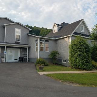 A modern gray house with a spacious driveway and well-maintained garden.