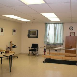 A spacious physical therapy room equipped for rehabilitation exercises.