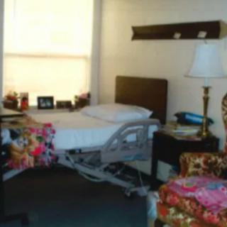 A cozy hospital room with a bed and a lamp.
