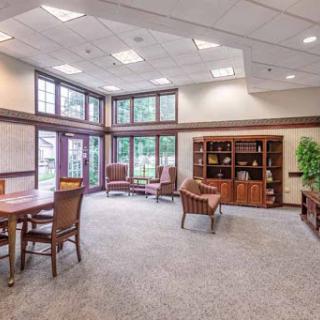 A spacious and well-lit office area featuring comfortable seating, bookshelves, and a warm ambiance suitable for meetings or relaxation.