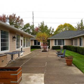 A courtyard between buildings with a paved walkway and planters.