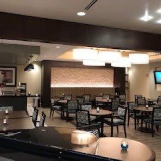 Modern restaurant interior with tables and chairs.
