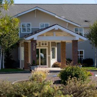 A residential building with a landscaped entrance and surrounding greenery.