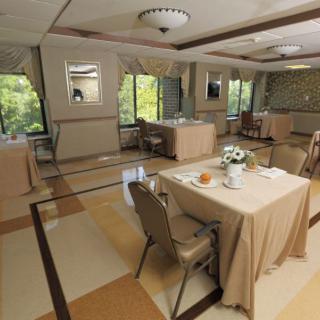 An elegant dining area with neatly arranged tables and chairs, adorned with tablecloths, providing an inviting atmosphere.