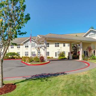 A sunny day view of a residential building with landscaped surroundings.