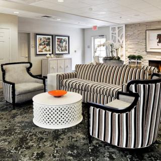 A modern living room with striped furniture and a stylish coffee table.