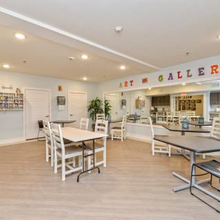 A modern art gallery interior with tables and chairs.