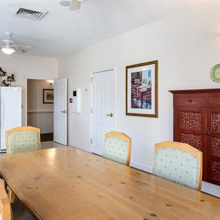 A dining room with a wooden table, chairs, and wall artwork.