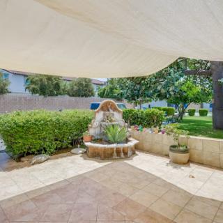 A serene outdoor space featuring a charming fountain surrounded by lush greenery.