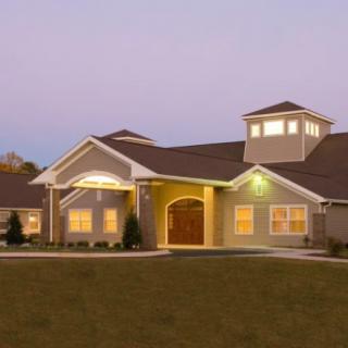 A well-lit residential house at dusk.