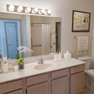 A well-lit bathroom featuring a modern vanity with a sink, decorative elements, and a clean aesthetic.
