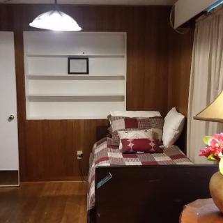 Cozy bedroom with wood paneling and a neatly made bed.