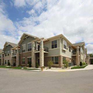 A modern residential building with stone accents under a partly cloudy sky.