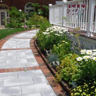 A beautifully landscaped garden path bordered by colorful flowers and greenery.