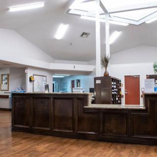 A modern reception area with a wooden desk and bright lighting.