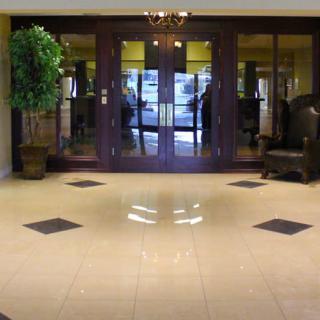 A spacious lobby entrance with glass doors, decorative plants, and comfortable seating.