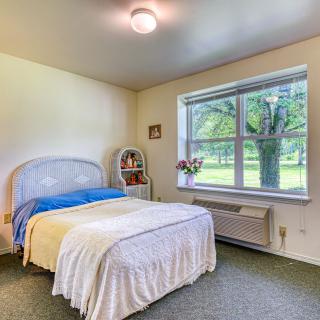 A cozy, minimalist bedroom with a large window allowing natural light to fill the space.
