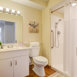 A modern bathroom featuring a shower, toilet, and sink with bright lighting and tasteful decor.