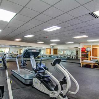A well-equipped gym featuring various exercise machines and a spacious workout area.