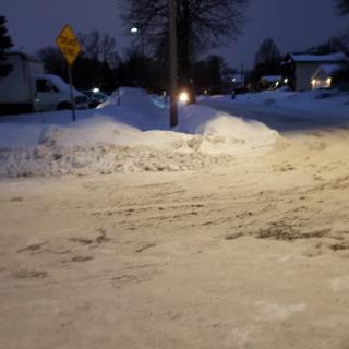 A snowy street illuminated by street lights during the night.