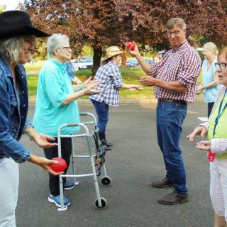A group of people participating in an outdoor activity, engaging in conversation and exercise.