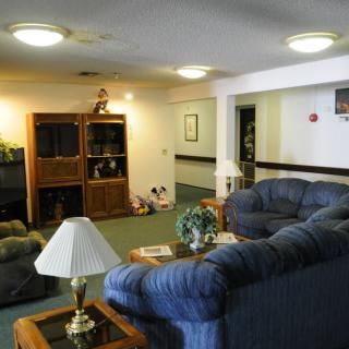 A cozy living room with a sofa set, coffee table, lamp, and an entertainment center.