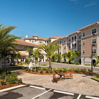 A sunny day at a residential complex with palm trees and well-maintained landscaping.