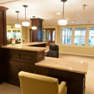 A well-lit reception area featuring a large desk and comfortable seating.