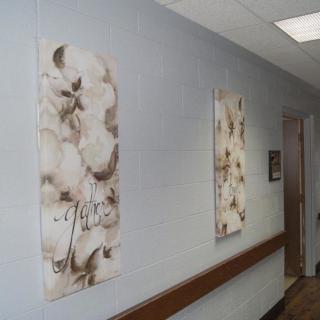 A hallway with floral paintings on the walls.