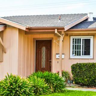 A small residential house with a landscaped front yard.