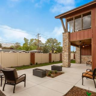 Modern backyard patio with outdoor seating and fire pit.