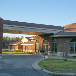 A modern brick building with a covered driveway under clear skies.