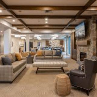 A spacious and modern living room with comfortable seating and a cozy fireplace.