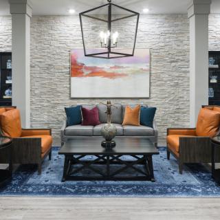 A modern living room with stylish furniture and a textured wall backdrop.