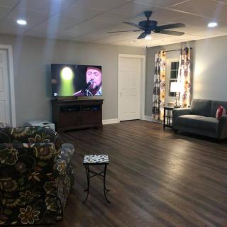A cozy living room with a television, sofa, and hardwood floor.