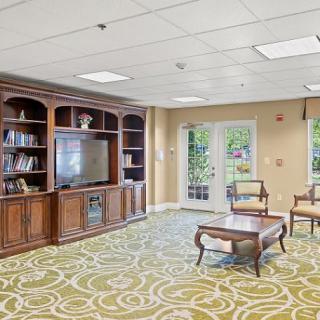 A cozy living room with a television, bookshelves, and comfortable seating.