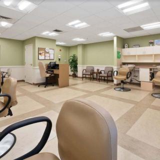 A spacious waiting room with chairs and a reception desk.