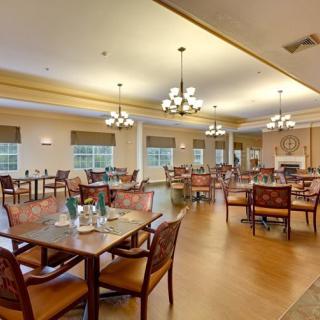 Spacious and elegantly decorated dining hall with multiple tables and ambient lighting.