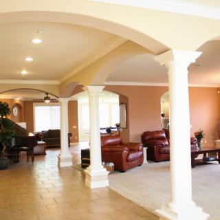 Spacious living area featuring elegant columns and comfortable furnishings.