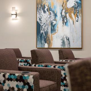 A modern interior with upholstered chairs and an abstract painting on the wall.