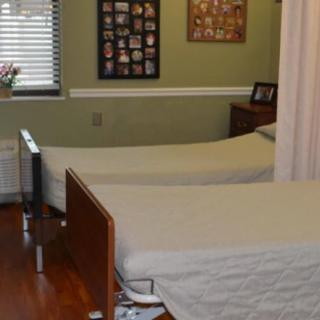 A hospital room with two beds separated by a curtain.