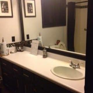A neatly organized bathroom with a sink, countertop, and mirror.